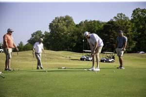 Golfers Putting During the Farmer Jim Neal